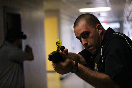 selective focus photography of man holding pistol thumbnail