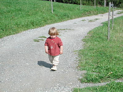 toddler wearing red top standing on pathway thumbnail