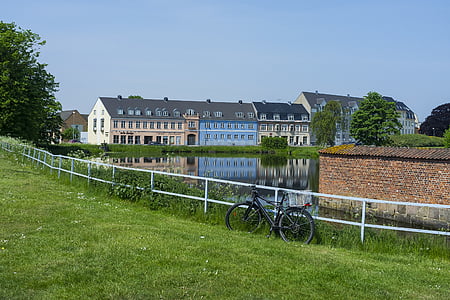 black bicycle leaning by rail near houses during daytime thumbnail