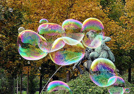 bubbles near gray concrete fountain and trees during daytime thumbnail