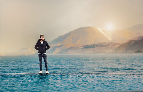 man standing on pool side near body of water during sunrise thumbnail