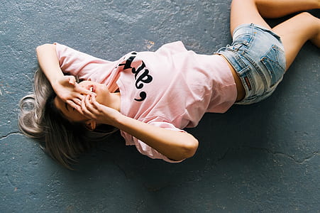 Woman Wearing Pink Printed Crew-neck T-shirt and Blue Faded Denim Shorts thumbnail