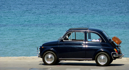 blue coupe on road near sea at daytime thumbnail