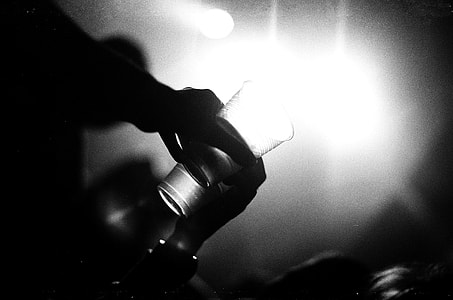 person holding highball glass grayscale photography thumbnail