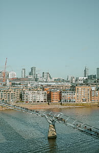aerial photography of people crossing water on grey bridge near city thumbnail