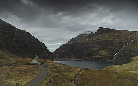 barn beside the road and lake during day thumbnail