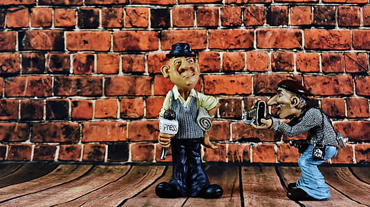 man holding microphone with man taking photo figurines thumbnail