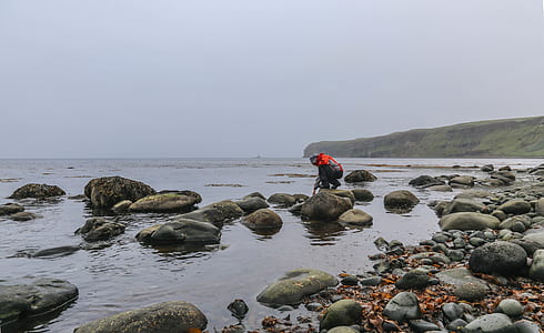 man standing on rock surrounded by water thumbnail