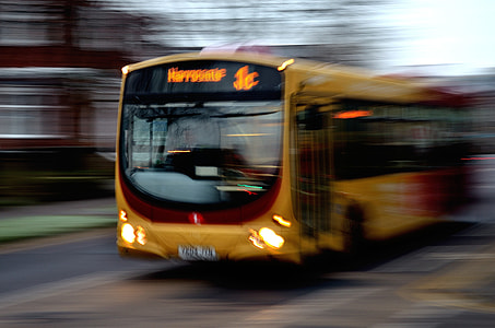 time lapse photography of yellow bus on road during daytime thumbnail