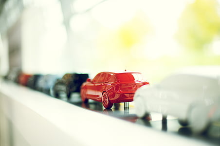 red die-cast model car on window thumbnail