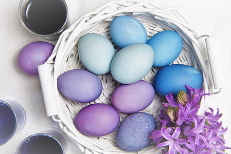 assorted painted eggs on round white wicker basket thumbnail
