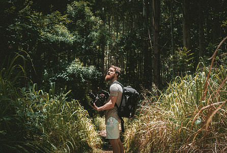 man wearing brown shirt with black backpack thumbnail