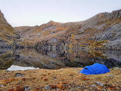 blue camping tent near lake water thumbnail
