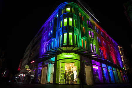 concrete building with assorted lights at night time thumbnail