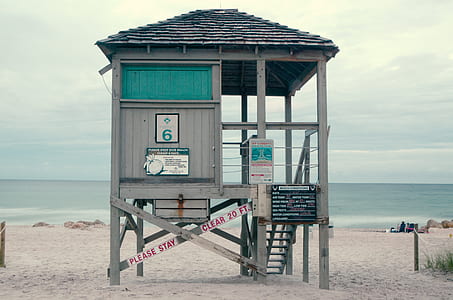 grey wooden shed beside body of water thumbnail
