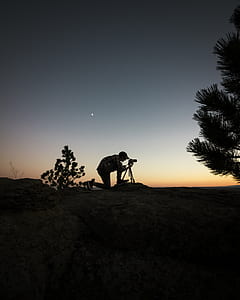 man holding camera beside tree thumbnail