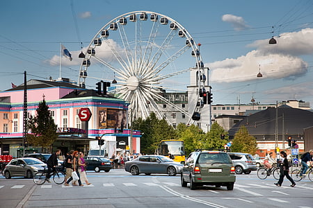 people crossing road in low traffic near Ferris wheel thumbnail