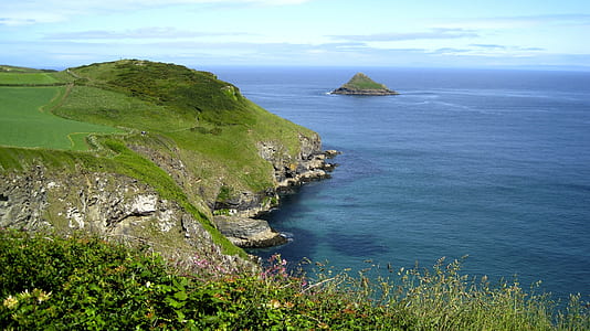 landscape photo of hill near body of water thumbnail