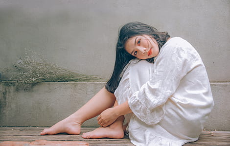 Woman Wearing White Dress Sitting on Wooden Floor thumbnail