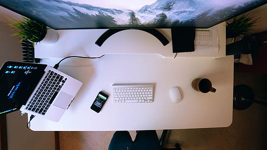 Apple keyboard and mouse near laptop thumbnail