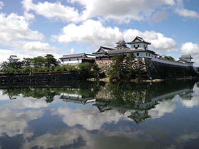 white Japanese castle beside body of water thumbnail