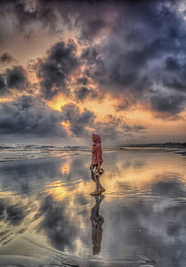 illusion photography of woman standing on body of water thumbnail
