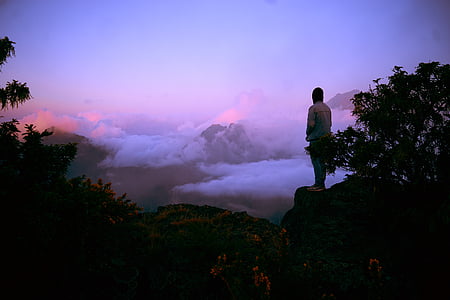 person standing on mountains during sunset thumbnail