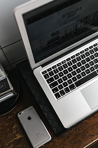 Front view of laptop and mobile phone on the wooden desk thumbnail