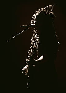 man with dreadlocks using microphone inside dark room thumbnail