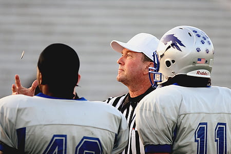 referee standing beside two football players thumbnail