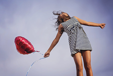photo of woman holding red heart balloon thumbnail