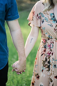 selective focus photograph of woman and man holding hands thumbnail
