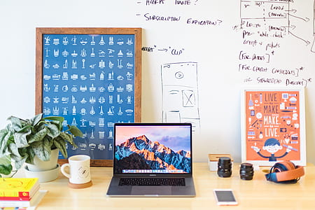 turned on MacBook Pro on brown wooden desk thumbnail