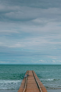 brown wooden dock under white and blue sky at daytime thumbnail