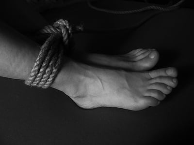 grayscale photo of feet tied with rope thumbnail
