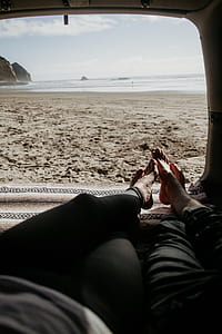 two person on vehicle lying facing beach at daytime thumbnail