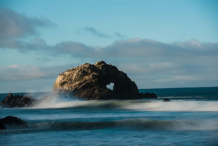 rock formation on sea with waves at daytime thumbnail
