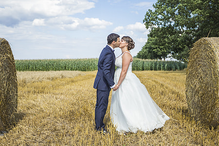 kissing couple in wedding suit and dress surrounding hay thumbnail