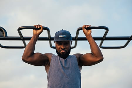 A young african man doing chin-up exercise outdoors thumbnail