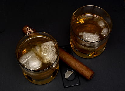 cigar between two shot glasses on black textile thumbnail