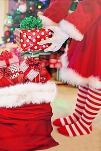person wearing Santa costume holding giftbox thumbnail