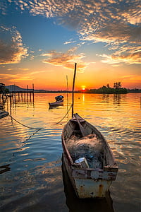 brown clinker boat on top of rippling body of water thumbnail