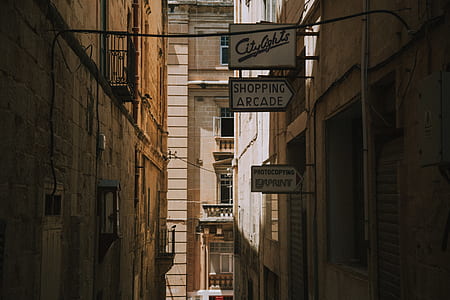 white and black signs in between buildings at daytime thumbnail