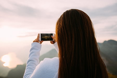 selective focus photography of woman holding smartphone thumbnail
