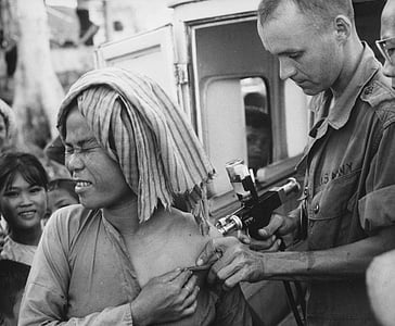 grayscale photography of soldier beside girl standing beside vehicle thumbnail