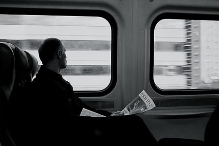 grayscale photo of a man looking at window thumbnail