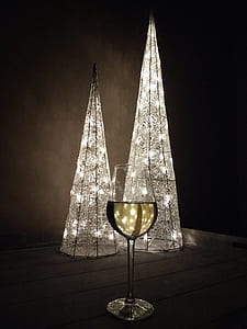lighted two Christmas trees beside wine glass thumbnail