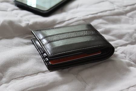 black leather bi-fold wallet on bed thumbnail