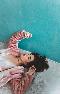 woman lying near green painted wall during daytime thumbnail