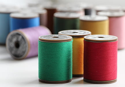 assorted-color thread lot on white surface thumbnail